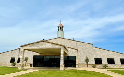 Lighthouse Fellowship church building exterior with white bell tower and modern stone facade